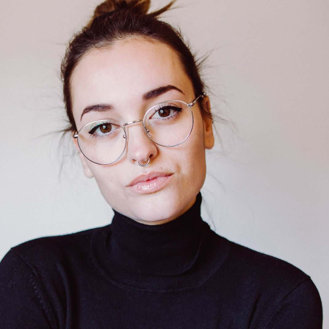 A photo of a woman with a septum peircing and glasses